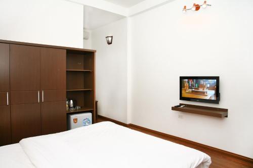 a bedroom with a bed and a flat screen tv at Bluebell Hotel in Hanoi