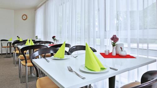a dining room with tables with yellow party hats on them at Appartis - Hotel am Stadtpark in Sindelfingen