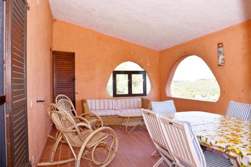 a room with a table and chairs and a couch at Villa Miriam in Monte Nai