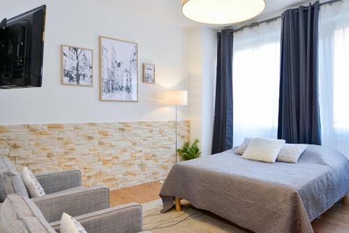 トゥールーズにあるNice Flat Ramblas Centre Toulouseのベッドルーム(ベッド1台、ソファ、テレビ付)