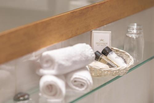 a shelf with toilet paper and a basket on it at Hotel Dreiflüssehof Haupthaus in Passau