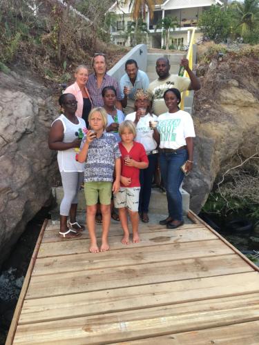 a group of people standing on a wooden bridge at Green Roof Inn in Carriacou