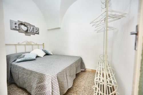 a white bedroom with a bed and a pole at EQUORUM 13 - Ostuni Centro in Ostuni