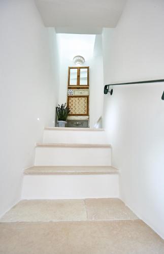 a stairway with white walls and white stairs at EQUORUM 13 - Ostuni Centro in Ostuni