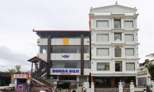 un gran edificio blanco con un cartel. en Treebo Trend Durga Boji Grand Gonikoppal Town en Gonikoppal