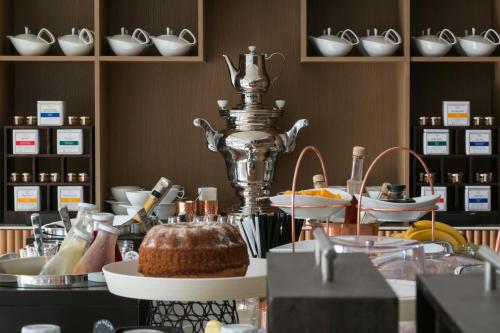 a bakery with a cake on a counter with dishes at Adriana Hvar Spa Hotel in Hvar