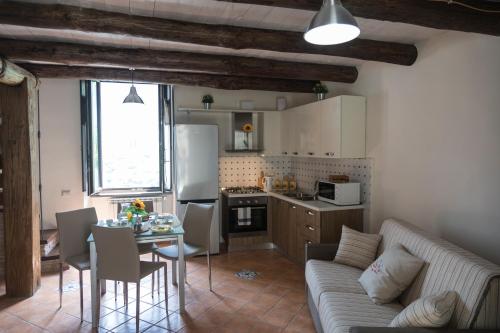 a kitchen and a living room with a couch and a table at TRA... INCANTO E NATURA in Tramonti