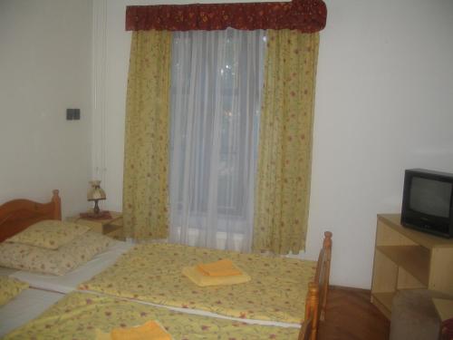 a bedroom with two beds and a window at Krisztina Panzió in Balatonalmádi