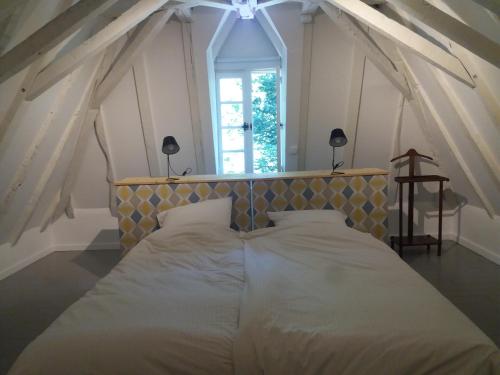 duże łóżko w pokoju z oknem w obiekcie La Chapelle du Chateau Gîte w mieście Pouillon