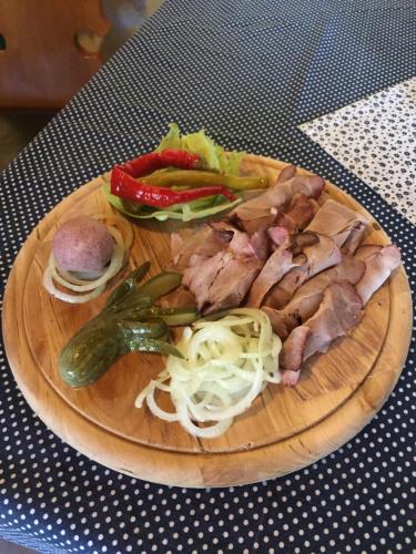 a plate of food with meat and vegetables on a table at Hotel Sirákov in Liptál