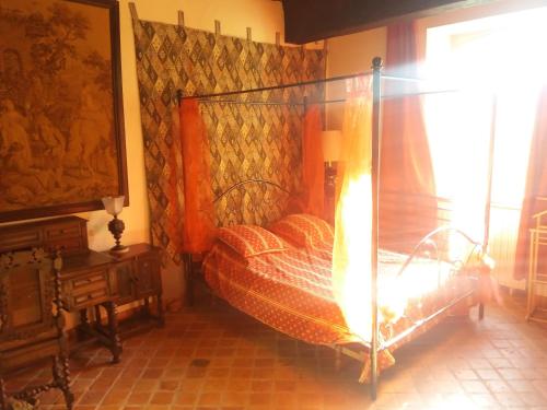 ein Schlafzimmer mit einem Himmelbett in der Unterkunft Commanderie des Templiers in Figeac