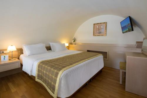 a hotel room with a large bed and a desk at Thalassa Beach Resort & Spa (Adults Only) in Agia Marina Nea Kydonias