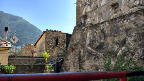 a stone wall with a building next to a mountain at Casa Pablo in Badalucco