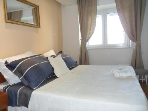 een slaapkamer met een groot bed met blauwe en witte kussens bij House Marija in Brela