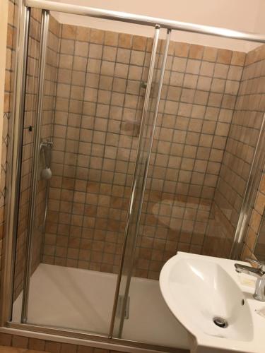 une douche avec une porte en verre à côté d'un lavabo dans l'établissement La Torre, à Taurianova