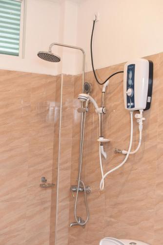 a shower in a bathroom with a phone on the wall at Kithmi Resort in Polonnaruwa