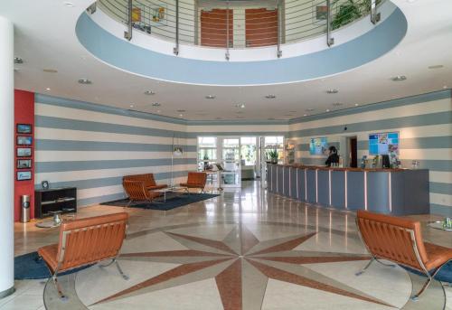 a lobby of a hospital with chairs and a counter at Globana Airport Hotel in Schkeuditz