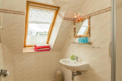 a small bathroom with a sink and a window at Haus Arvert in Koserow