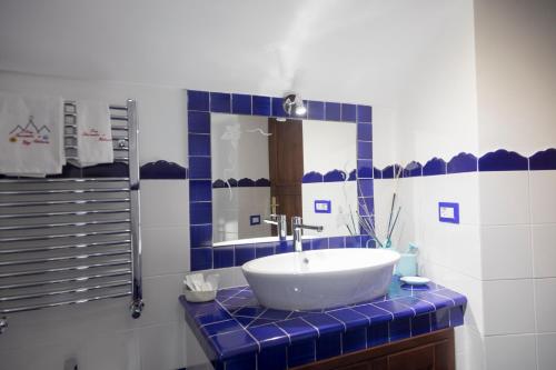 a blue and white bathroom with a sink and a mirror at TRA... INCANTO E NATURA in Tramonti