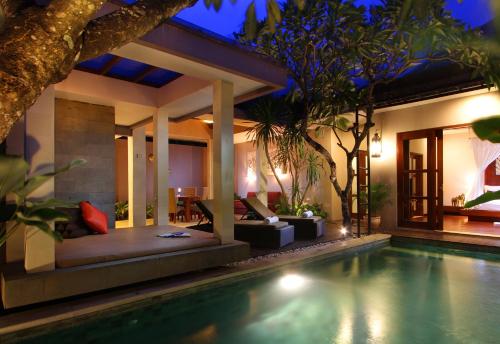 a villa with a swimming pool at night at Aria Exclusive Villas & Spa - CHSE Certified in Seminyak