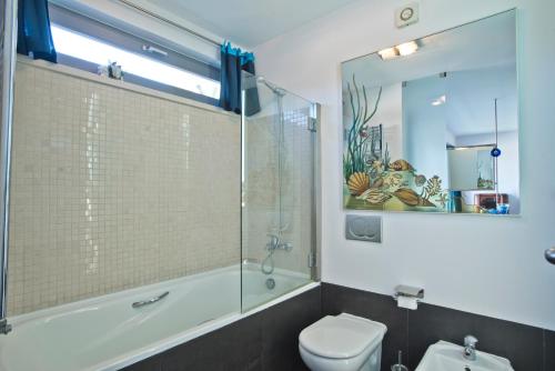 a bathroom with a glass shower and a toilet at Villa Casalinho Meco in Aldeia do Meco