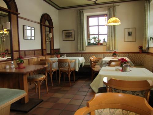 ein Restaurant mit Tischen und Stühlen in einem Zimmer in der Unterkunft Pension Zur Alten Schmiede in Zwiesel