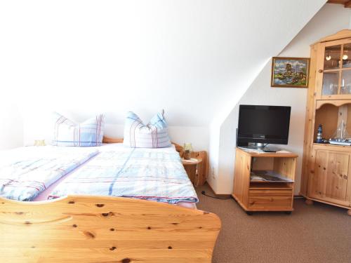 PepelowにあるNice holiday room in Pepelow on the Baltic Seaのベッドルーム1室(ベッド1台、木製キャビネット内のテレビ付)