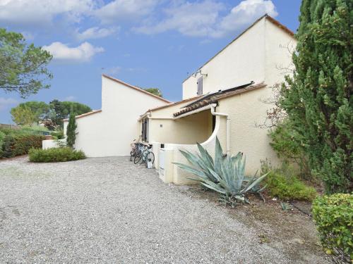 - un bâtiment blanc avec des vélos garés à l'extérieur dans l'établissement Cosy villa with private garden in Saint Cyprien, à Latour-Bas-Elne