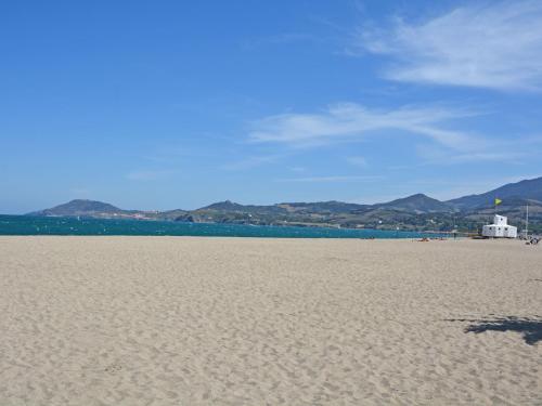 une plage de sable avec l'océan et les montagnes en arrière-plan dans l'établissement Cosy villa with private garden in Saint Cyprien, à Latour-Bas-Elne