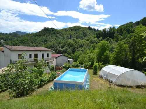 a greenhouse and a swimming pool in a field at Belvilla by OYO Il Pradaccio in Molazzana