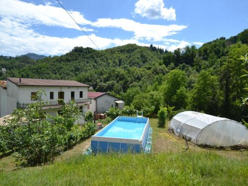 ein Gewächshaus und ein Pool auf einem Feld in der Unterkunft Belvilla by OYO Il Pradaccio in Molazzana