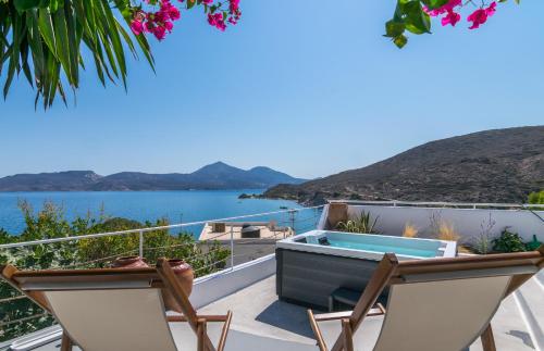 a balcony with a hot tub and a view of the ocean at Villa SOLEIL in Adamas