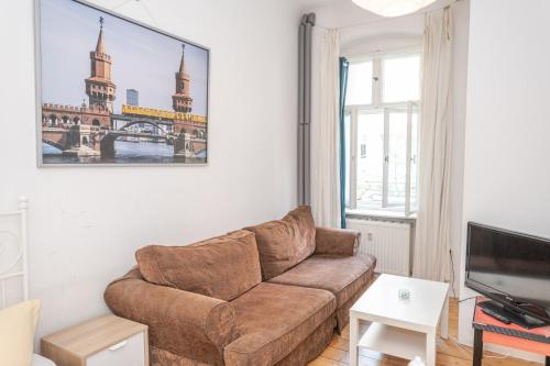 uma sala de estar com um sofá e uma televisão em BackpackerBerlin em Berlim