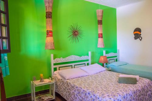 Dormitorio verde con cama y pared verde en Pousada Lagoa Pequena, en Prado