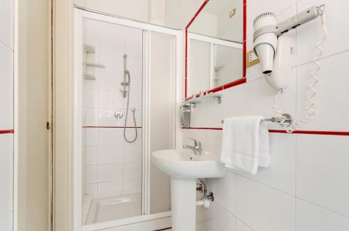 a white bathroom with a sink and a shower at Hotel Original in Turin