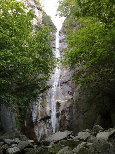 a waterfall on the side of a mountain with trees at Hotel Rural-Spa Resguard Dels Vents in Ribes de Freser