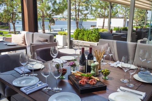 a wooden table with wine glasses and food on it at Riviera Zoloche Resort & Spa in Vishenki