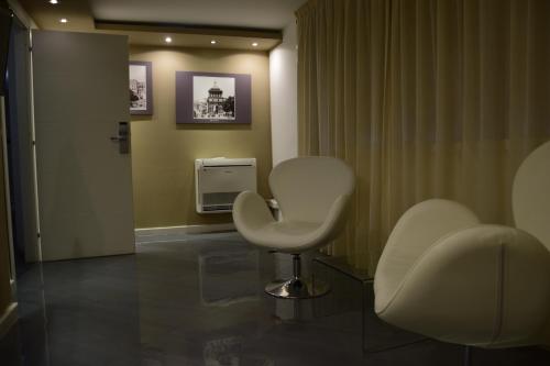 a salon with two white chairs and a hair dryer at Ibis Styles Palermo Cristal in Palermo
