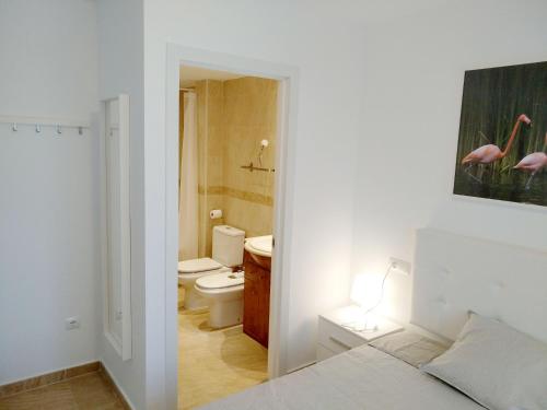 a bathroom with a bed and a bathroom with a toilet at Mi Apartamento en el Delta del Ebro+ in Deltebre