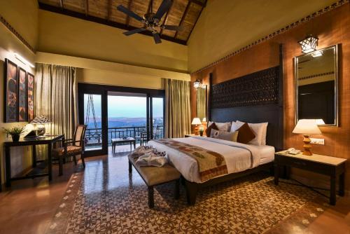 a bedroom with a large bed and a balcony at The Fern Samali Resort in Dapoli