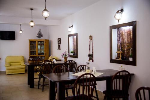 a dining room with a table and chairs at Casa de sub deal in Bîltişoara