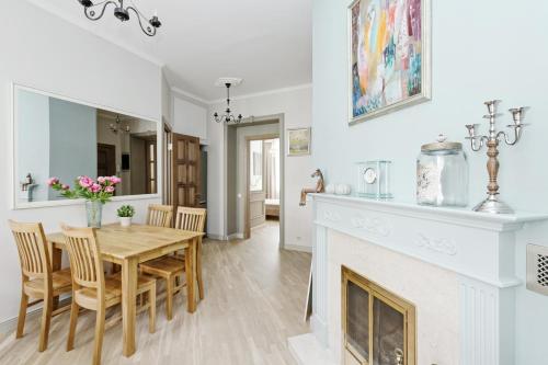 uma sala de estar com uma mesa de jantar e uma lareira em Ausekla Deluxe Apartment em Riga