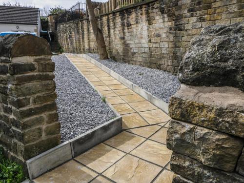 a garden with rocks and a brick wall at The Button Box in Huddersfield