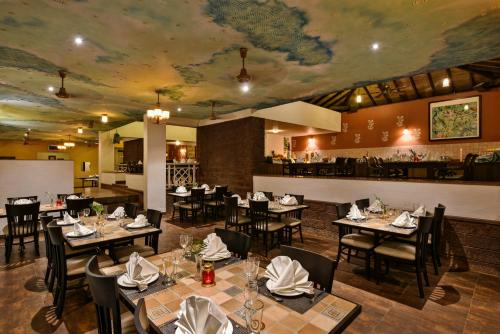 a restaurant with tables and chairs with a map on the ceiling at The Fern Samali Resort in Dapoli