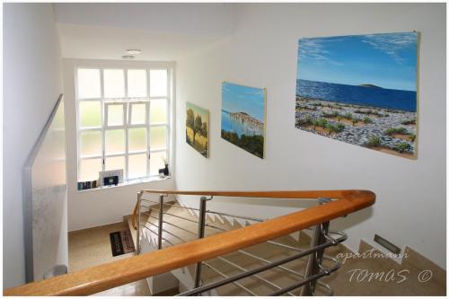 a staircase with three paintings on the wall at Apartments Tomas in Primošten