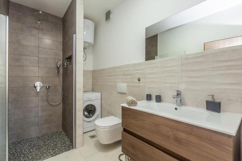 a bathroom with a sink and a washing machine at Apartment Brzac in Brzac