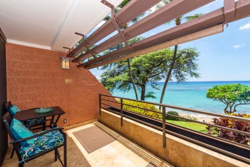 a balcony with a table and a view of the ocean at Kuleana 713 in Lahaina