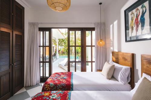 une chambre avec un lit et une porte coulissante en verre dans l'établissement Villa Luma, à Seminyak