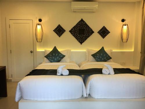 two beds in a bedroom with lights on the wall at Sahaa Beach Resort in Sihanoukville