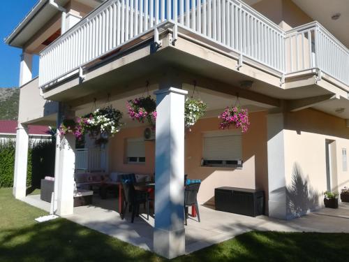 a house with a balcony with flowers on it at Riverside Guesthouse in Počitelj